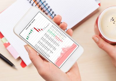 woman-holding-smartphone-above-business-desk-DPRZ3JT.jpg
